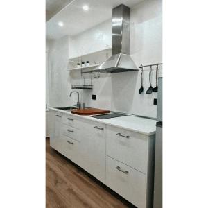 a kitchen with white cabinets and a sink at The Hemme's Home in Genova