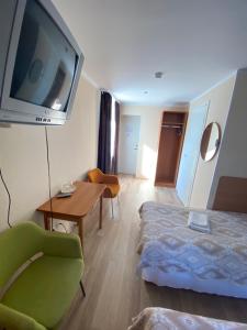 Habitación de hotel con cama y TV en la pared en Laine guesthouse, en Narva-Jõesuu
