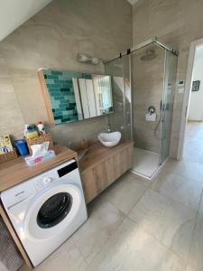 una lavatrice in un bagno con doccia di Fenyves Beach Apartman Delux a Balatonfenyves Altre 22 foto