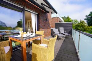 een patio met een tafel en stoelen op een balkon bij Ferienwohnung Daldrup 2 in Grömitz