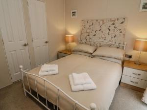 ein Schlafzimmer mit einem Bett mit zwei Handtüchern darauf in der Unterkunft Number 15 in Carnforth
