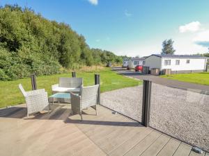 eine Terrasse mit Tisch und Stühlen auf einem Deck in der Unterkunft Number 15 in Carnforth