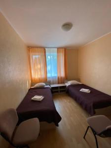Cette chambre comprend 2 lits et une fenêtre. dans l'établissement Laine guesthouse, à Narva-Jõesuu