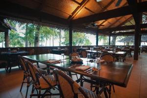 una sala da pranzo con tavoli e sedie in un ristorante di Sangat Island Dive Resort a Coron
