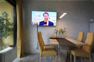 a television hanging on a wall in a room with a table at Manhattan 516 mit Schwimmbad in Braunlage