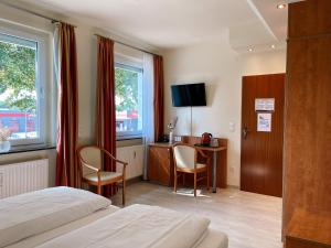 um quarto de hotel com uma cama e uma secretária com cadeiras em Hotel Falk em Bremen