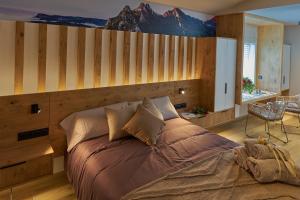 - une chambre avec un grand lit orné d'une fresque murale représentant la montagne dans l'établissement HOTEL LA CABANA BERGA, à Berga