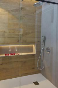 a bathroom with a shower with two wine glasses at HOTEL LA CABANA BERGA in Berga