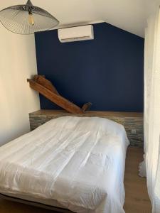 een slaapkamer met een wit bed en een blauwe muur bij Maison face à la Cathédrale in Bourges