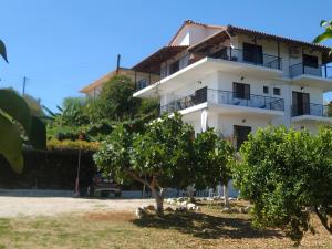 a white building with trees in front of it at Bousounis Apartments in Chrani