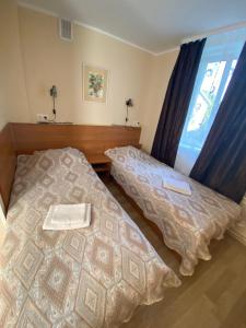 sypialnia z 2 łóżkami i oknem w obiekcie Laine guesthouse w mieście Narva-Jõesuu
