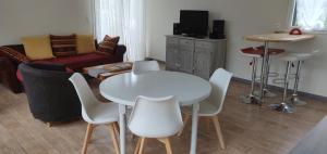 Maison avec Spa en bord de mer في لوغونا داوْلا: غرفة معيشة مع طاولة وكراسي بيضاء