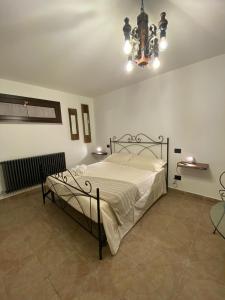 1 dormitorio con cama y lámpara de araña en ZuliHome, en Oliveri