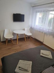 Zimmer mit einem Tisch, 2 Stühlen und einem TV in der Unterkunft Apartament Japko in Gliwice