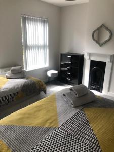 a bedroom with two beds and a fireplace at 2 Bedroom Luton Townhouse in Luton