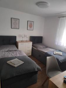1 Schlafzimmer mit 2 Betten, einem Schreibtisch und einem Stuhl in der Unterkunft Apartament Japko in Gliwice