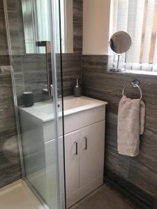 a bathroom with a sink and a glass shower at 2 Bedroom Luton Townhouse in Luton
