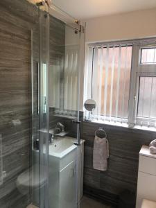 uma casa de banho com um lavatório e uma cabina de duche em vidro. em 2 Bedroom Luton Townhouse em Luton