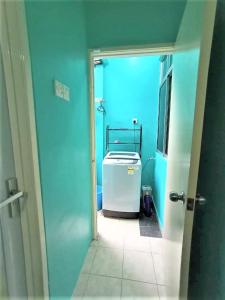 a bathroom with a blue room with a refrigerator in it at The Handz House II with WIFI - For family or same gender only in Kepala Batas