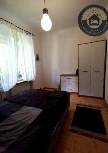 1 dormitorio con 1 cama, vestidor y ventana en JUNA - nowoczesny apartament w centrum z widokiem na park, en Pruszków