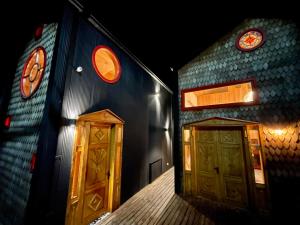 a building with two wooden doors on the side at Bledford Chiloé in Castro