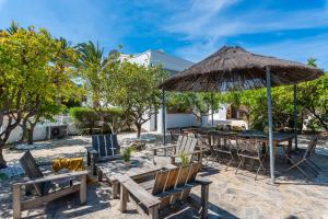 a patio with a table and chairs and an umbrella at Villa Reva - PlusHolidays in Calpe