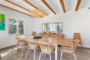 a dining room with a wooden table and chairs at Villa Reva - PlusHolidays in Calpe