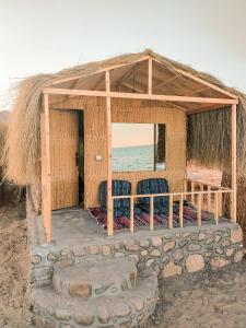 a hut with two chairs and a view of the ocean at Sinai Life Beach Camp in Nuweiba