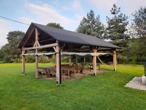 a wooden pavilion with a picnic table in a park at HARCÓWKA in Złoty Stok