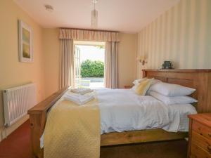 a bedroom with a bed with white sheets and a window at Foxes Den in Saint Goran