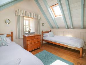 een slaapkamer met 2 bedden, een raam en een dressoir bij Dovecote in Saint Goran