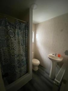 y baño con lavabo, aseo y ducha. en World's End Hostal en Puerto Natales