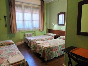 a room with three beds and a window at Hostal San Martin in Madrid