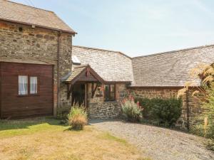 an old stone house with a driveway in front of it at Oak Cottage in South Molton