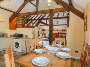 a kitchen and dining room with a wooden table and chairs at Oak Cottage in South Molton
