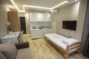 a small room with a bed and a kitchen at Apartmani Rekic-Dubai in Novi Pazar
