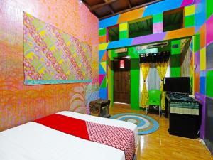 1 dormitorio con 1 cama y una pared colorida en OYO 91601 Double-Degree Syariah (Female & Family) en Sleman