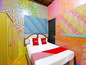 1 dormitorio con 1 cama con una pared colorida en OYO 91601 Double-Degree Syariah (Female & Family) en Sleman