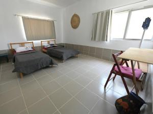 a room with two beds and a table and a chair at St.Jadoor Inn in Al Azraq ash Shamālī