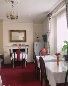 una sala da pranzo con 2 tavoli e un frigorifero di Mulgrave Lodge a Dun Laoghaire