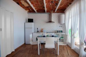 a kitchen with a white table and white chairs at LOFT CANET DE MAR CERCA de BARCELONA in Canet de Mar