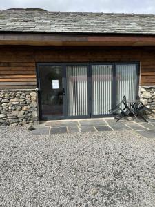 a building with a bench in front of a door at The Canteen Beautiful 1-Bed Apartment in Keswick in Threlkeld