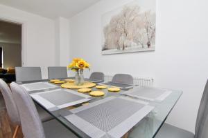 a dining room with a glass table with yellow cookies on it at Serene 7Bed Escape - Steps from Coventry City Center, Holiday Bliss! in Coventry