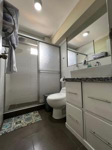 een badkamer met een toilet, een wastafel en een douche bij Departamentos Caraz in Caraz