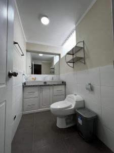 a white bathroom with a toilet and a sink at Departamentos Caraz in Caraz