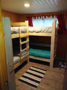 two bunk beds in a room with a window at Adilauquen Cabañas y Tinajas Calientes in Puerto Varas