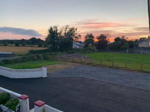 a parking lot with a sunset in a field at Family Farmhouse in Claregalway