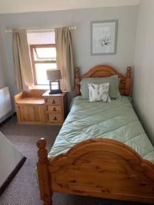 a bedroom with a wooden bed and a window at Family Farmhouse in Claregalway