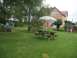 een picknicktafel met een paraplu in de tuin bij Cheltenham accommodation -self-catering-2 bedrooms in Cheltenham
