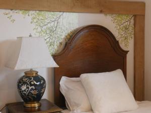 a bed with a wooden headboard and a lamp on a table at Cheltenham accommodation -self-catering-2 bedrooms in Cheltenham